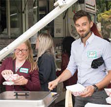 Staff near a food truck at the summer picnic