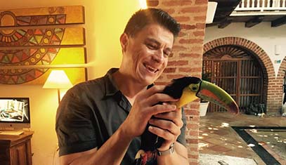 image of smiling man holding a toucan