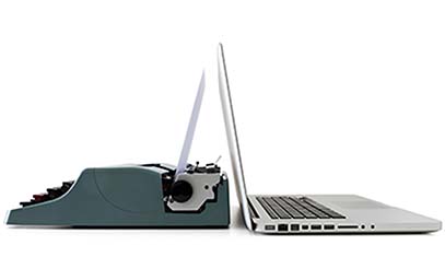 open laptop and typewriter back-to-back