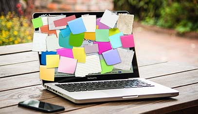 open laptop with post-it notes covering the screen
