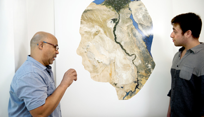 hamdi attia talks with a student about a map