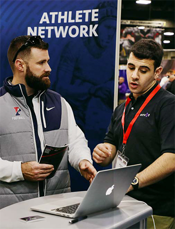 Ben Weiss selling technology at a convention to a bearded man.