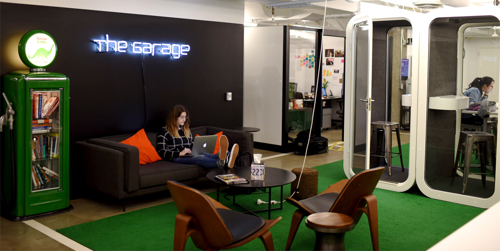 Woman sitting on couch with laptop in Northwestern's Garage